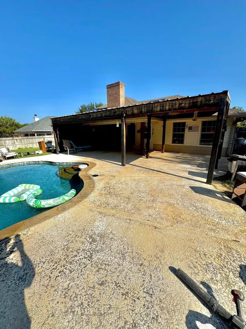 Bare aggregate concrete pool patio under a covered pergola before Pro-Flex resurfacing