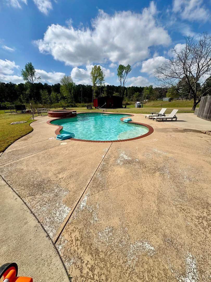 Cracked tan stamped concrete deck around a kidney pool before resurfacing
