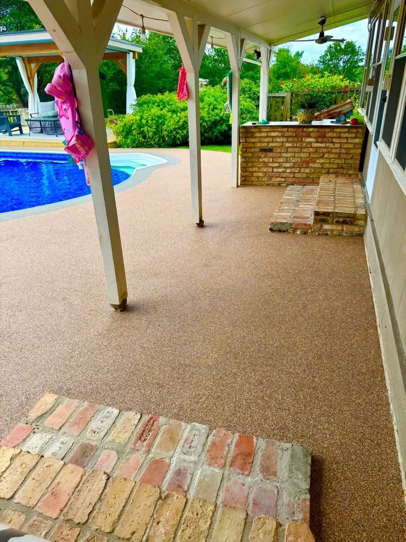Same covered porch finished in tan speckled surfacing with a brick entry step