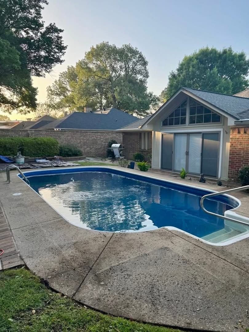 Plain gray concrete deck around a vinyl liner pool before resurfacing