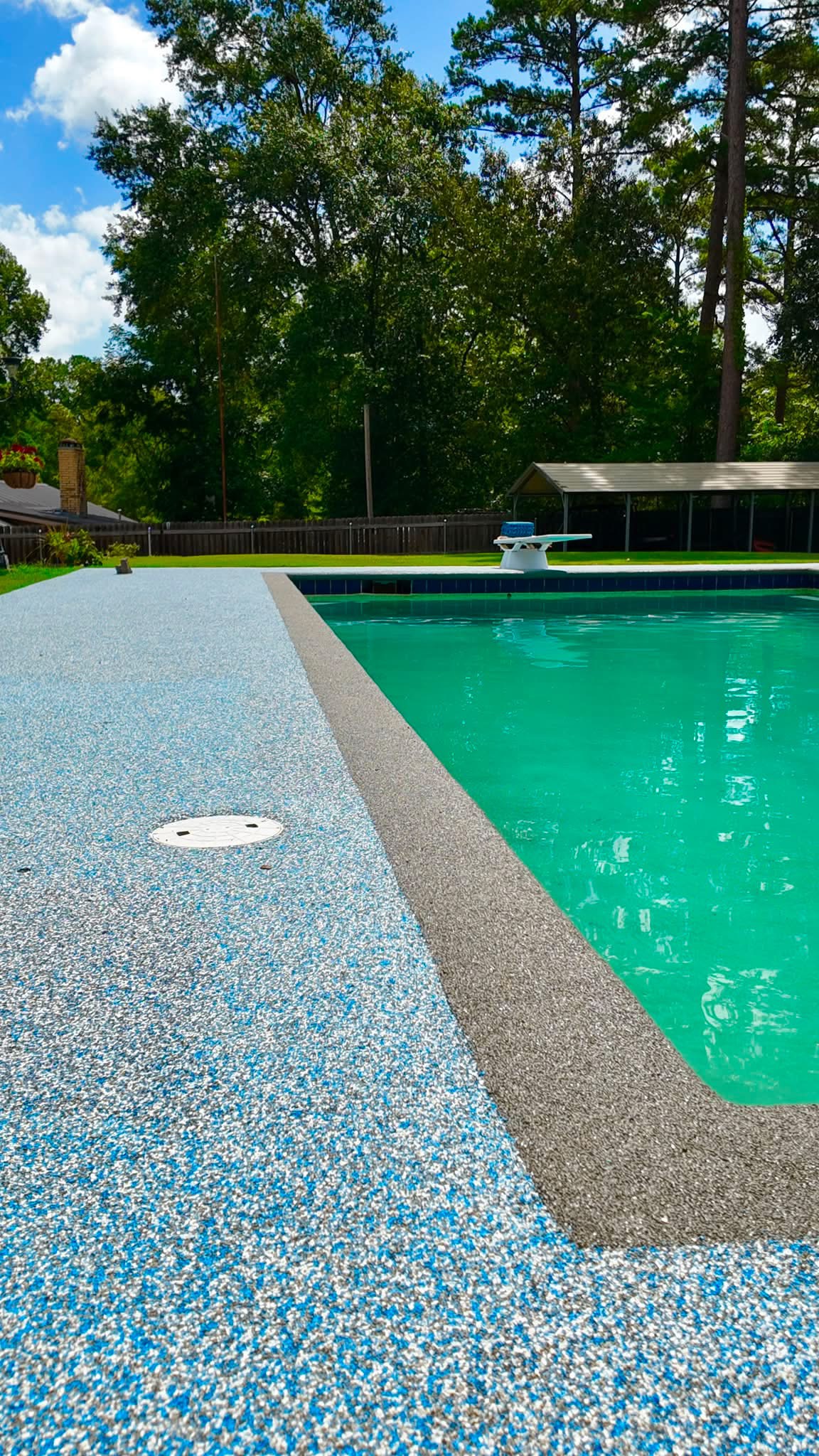 Close-up of light blue speckled deck surfacing bordering a diving pool