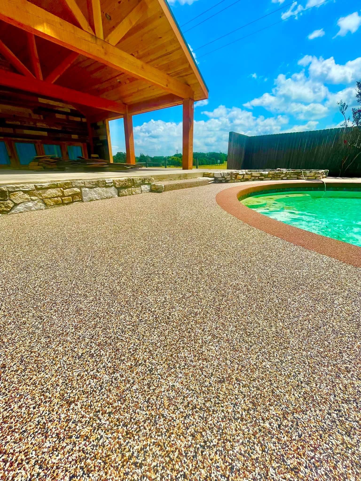 Close-up of gold speckled Pro-Flex deck curving around a round pool with red border