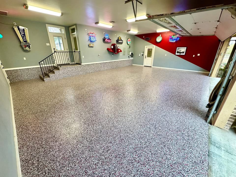 Car-themed garage with a red and gray accent wall finished in a speckled flake floor coating