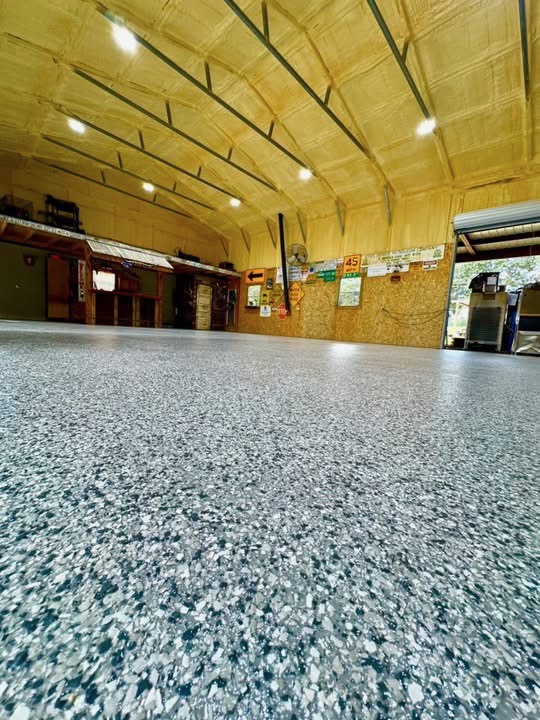 Large steel building interior finished with a gray speckled flake floor coating