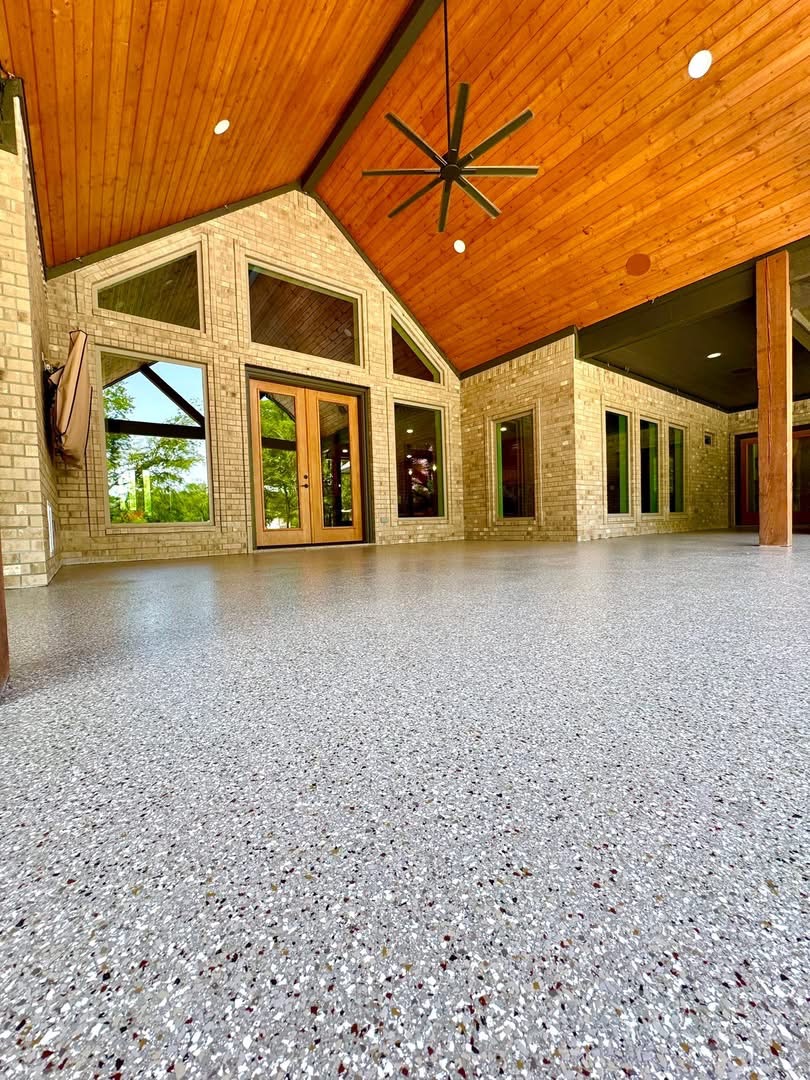 Covered patio with a vaulted wood ceiling finished in a gray speckled flake floor coating