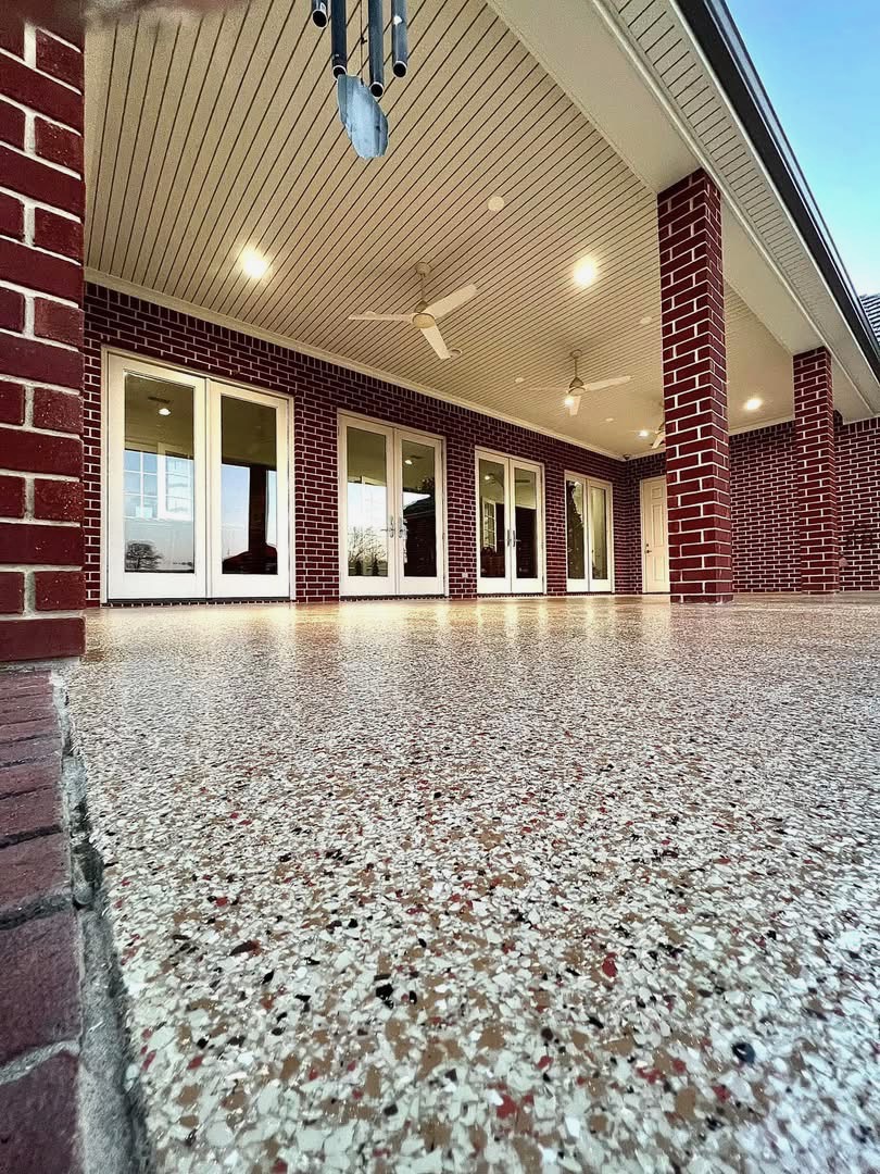 Covered patio with brick columns and ceiling fans finished in a speckled flake floor coating
