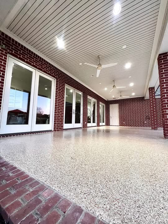 Covered patio corridor with brick columns finished in a gray speckled flake floor coating