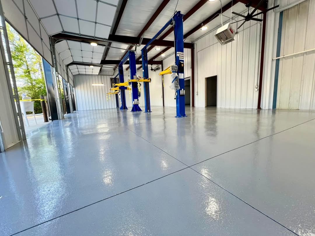 Automotive shop with vehicle lifts finished in a gray speckled flake floor coating