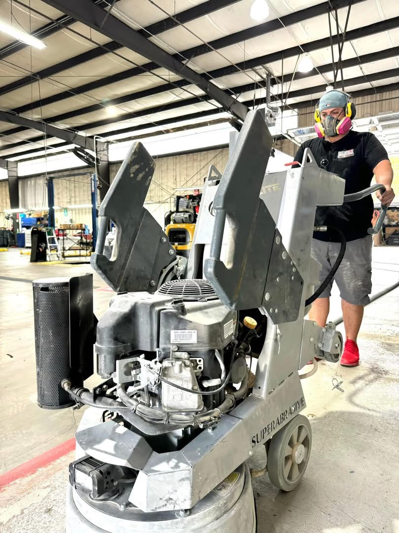 Crew operating professional grinding equipment during flake floor preparation