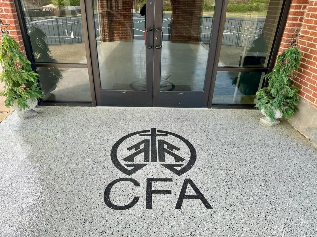 Commercial entrance floor finished with a speckled flake coating and a custom logo inlay